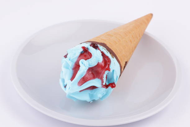 istock Ice cream in a waffle cup with blue stuffing and red jam on a white plate for designer 848898340