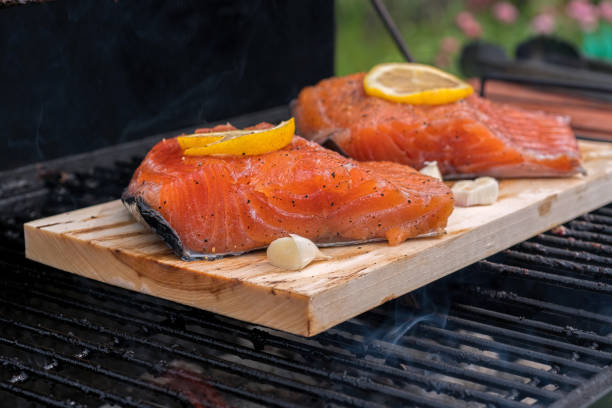 istock cedar plank salmon with lemon cooking on grill 848906542