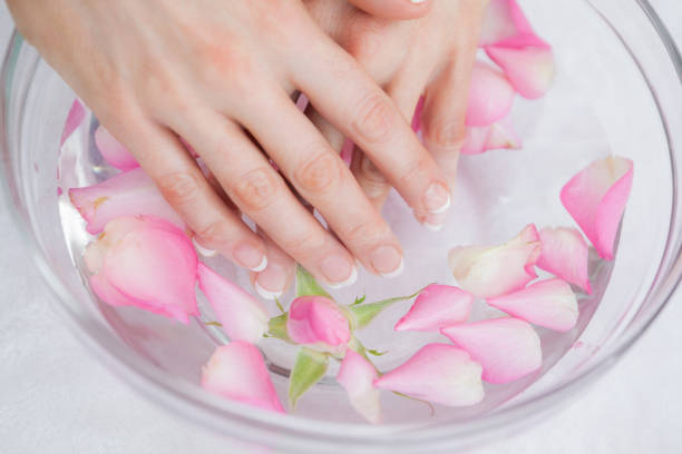 istock Womans hands in bowl with petals at hands spa 848918060