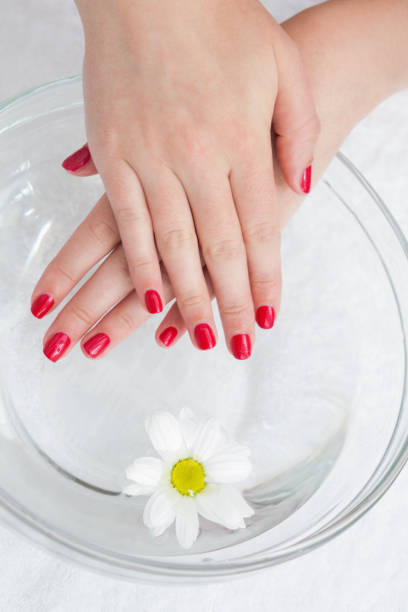 istock Red painted finger nails with flower in bowl 848918178