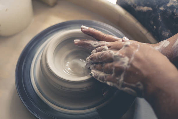 istock Dirty potter hands works with clay on pottery wheel 848929318