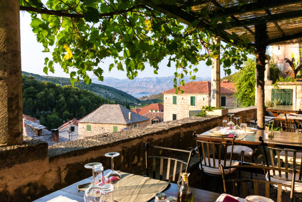 terrace with sea and mountain view - Croatia Terrace with tables and chairs with beautiful views of the town, sea and mountains. Dol - small town on Brac Island, Dalmatia, Croatia. Tourism. brac island stock pictures, royalty-free photos & images