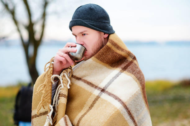 un jeune homme de boire un café avec coupe debout sur la beac automne - beach on child the photos et images de collection