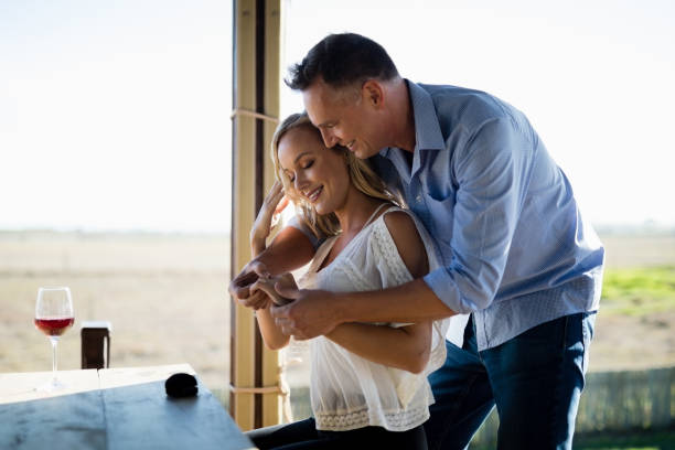 Smiling man wearing engagement ring to woman