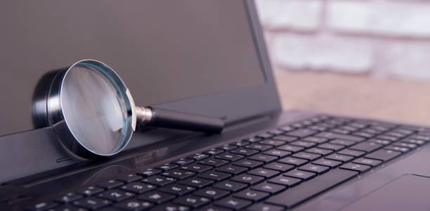 istock magnifying glass on black laptop 848953312