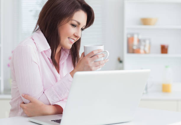 istock Smiling woman with coffee cup using laptop 848958972