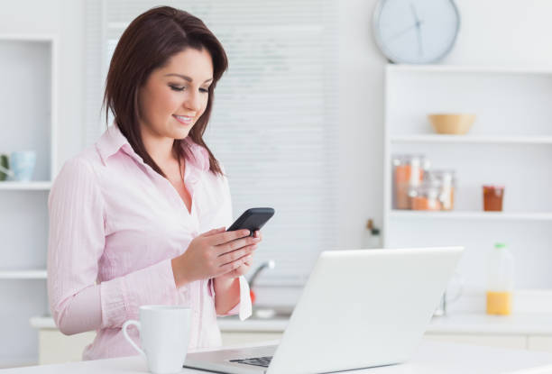istock Woman with coffee cup and laptop using cellphone 848959086