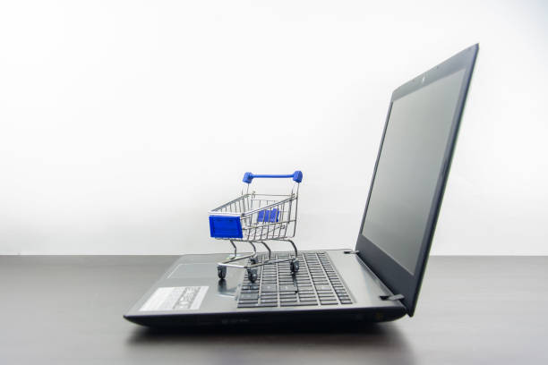 istock Computer notebook blank screen with shopping cart on wood table 848964198