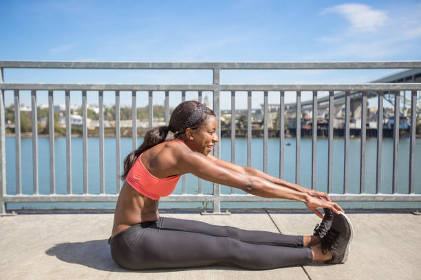 istock Attractive female athlete stretches on sidewalk before training session 848974816