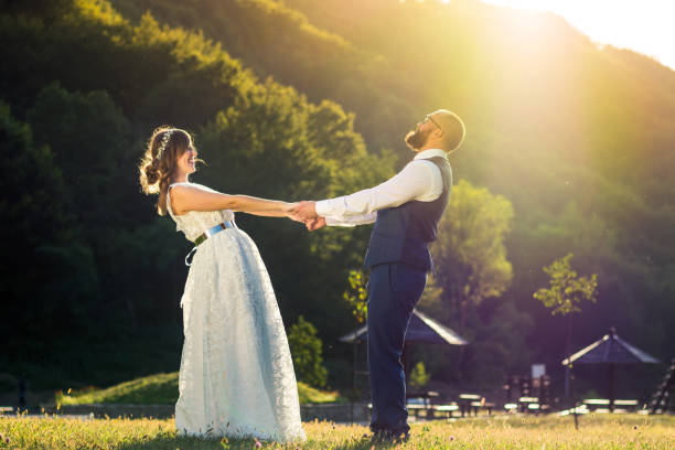 istock Bride and groom holding hands at sunset 848975192