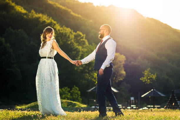 istock Bride and groom holding hands at sunset 848975352