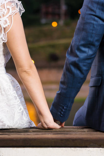 istock Bride and groom holding hands by the lake 848981352