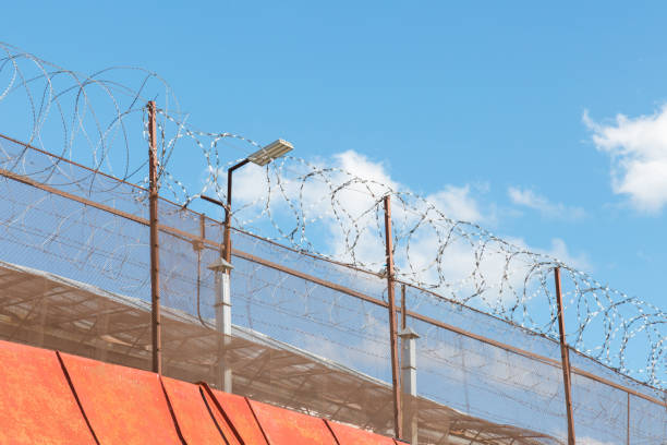 istock Barbed wire, fence and wall in prison 848985634