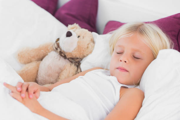 istock Cute girl sleeping near to her teddy bear 848985742