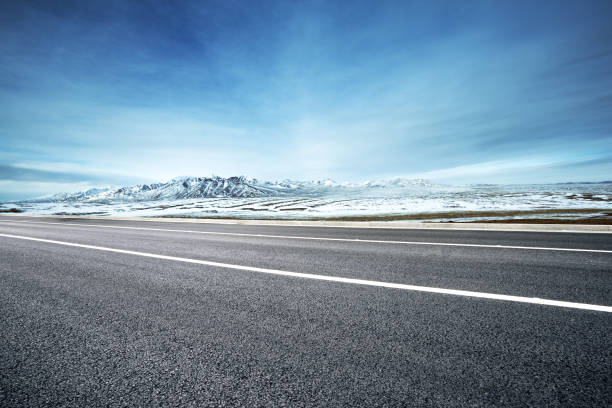 istock empty asphalt road with snow mountains in blue sky 849001120
