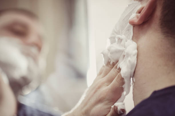 istock Man applying shaving cream on beard in the bathroom 849001854