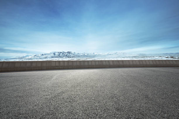istock empty asphalt road with snow mountains in blue sky 849004568