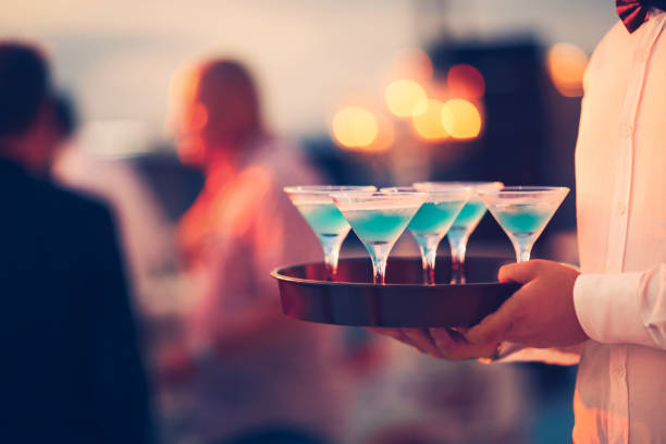 Nightlife - The waitress is offering blue hawaiian. Blue Hawaiian, Waiter, Bar - Drink Establishment, Unrecognizable Person, kalender stock pictures, royalty-free photos & images