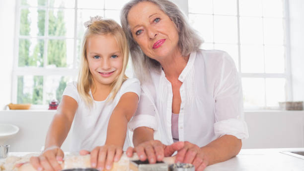 istock Smiling granddaughter making biscuits with her grandmother 849011930