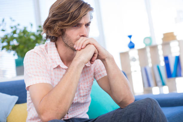 istock Depressed male executive sitting on sofa 849028668