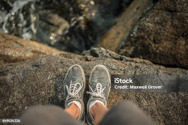 Shoes Standing On The Edge Of Cliff Over Ocean Stock Photo - Download Image Now - Cliff, At The Edge Of, Standing
