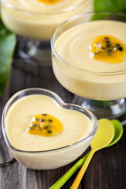 Passion fruit mousse vertical composition with colorful spoons stock photo