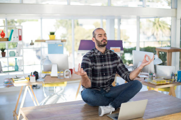 istock Male executive doing yoga in office 849062970