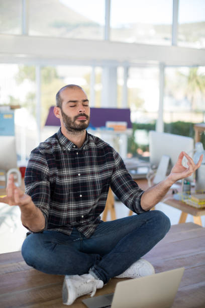 istock Male executive doing yoga in office 849063058