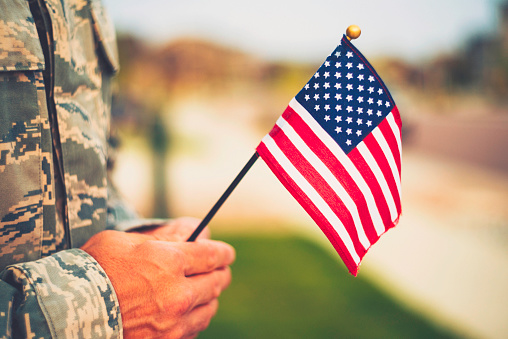 Día de los veteranos en Estados Unidos. Soldado con bandera americana photo