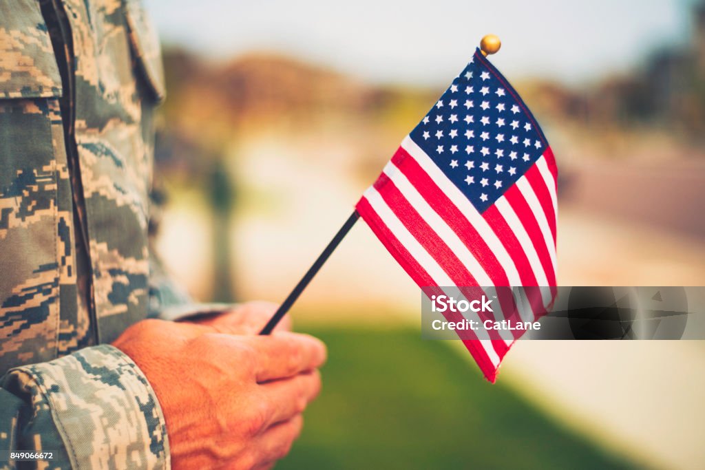 Veteran's Day in America. Soldier with American Flag US Veteran's Day Stock Photo