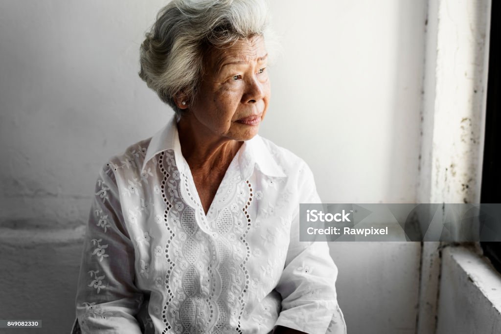 Vista lateral de la anciana Asia con expresión pensativa de la cara - Foto de stock de Tercera edad libre de derechos