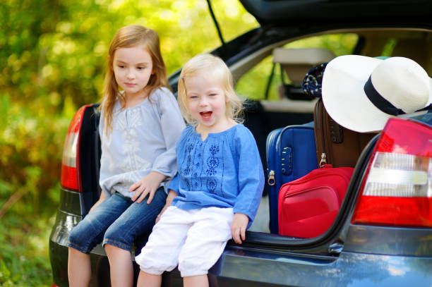 istock Two adorable little sisters sitting in a car 849086270