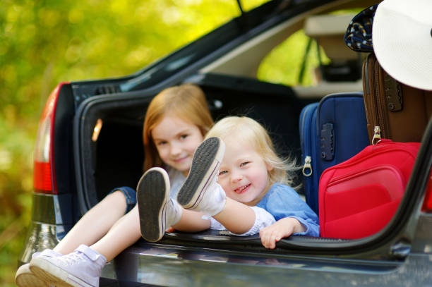 istock Two adorable little sisters sitting in a car 849096244