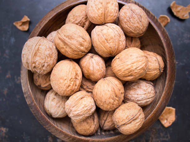 istock Walnut in a wooden bowl on dark rustic background 849103208