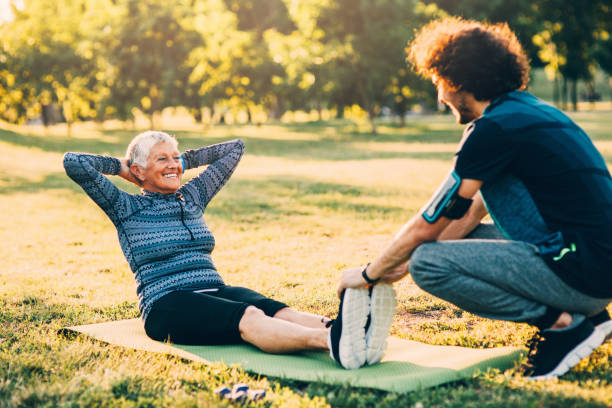 istock Senior woman doing crunches with a personal trainer 849109792