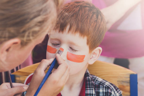 istock Child boy face painting, making tiger eyes process 849110278