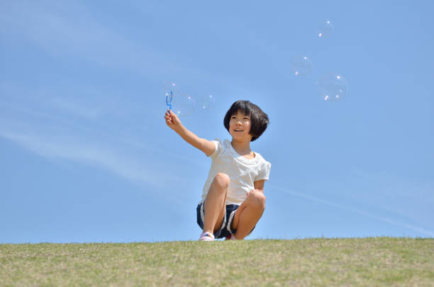 istock Girls playing with soap bubbles in the grassland 849120502