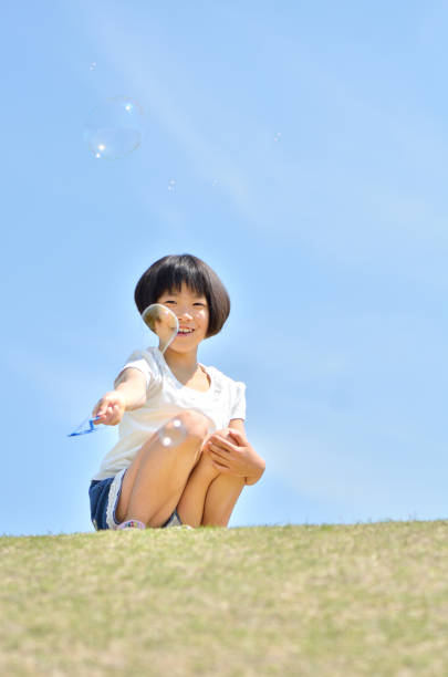 istock Girls playing with soap bubbles in the blue sky 849120508