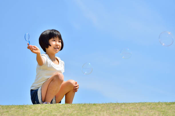 istock Girls playing with soap bubbles in the blue sky 849120518