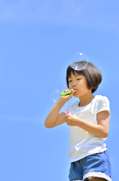 istock Girls blowing soap bubbles in the blue sky 849120536