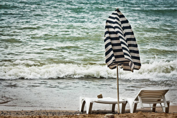 istock Easy storm on the sea, the broken beach umbrella 849124200