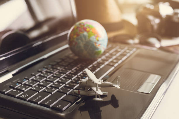 istock Toy airplane on laptop keyboard with globe and camera 849125436
