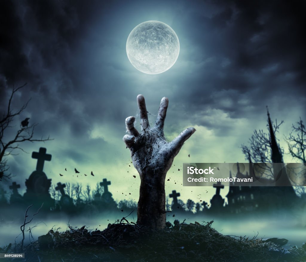 Zombie Hand Rising Out Of A Grave Zombie hand coming out of his grave Halloween Stock Photo