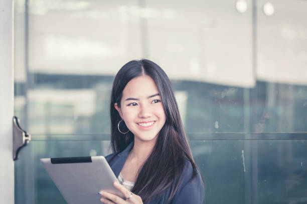 istock Young female passenger at the airport, using her tablet computer while waiting for her flight 849129048