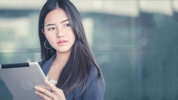 istock Young female passenger at the airport, using her tablet computer while waiting for her flight 849129096
