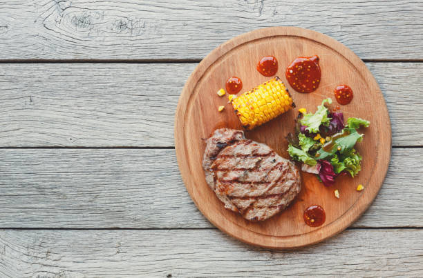 istock Grilled beef steak closeup on dark wooden table background 849129384