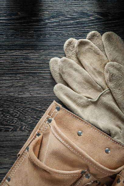 istock Leather building belt safety gloves on black board 849132500