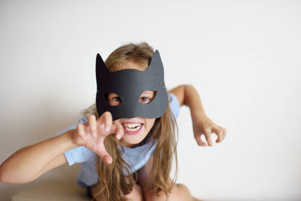 The girl plays in a self-made mask of black cat The girl plays in a self-made mask of black cat for Halloween zombie paper stock pictures, royalty-free photos & images