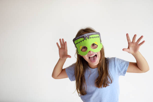 The girl plays in a self-made mask of Frankenstein The girl plays in a self-made mask of Frankenstein for Halloween zombie paper stock pictures, royalty-free photos & images