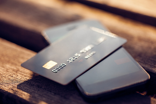 Credit card and mobile phone on a wooden background. Concept for mobile payments.